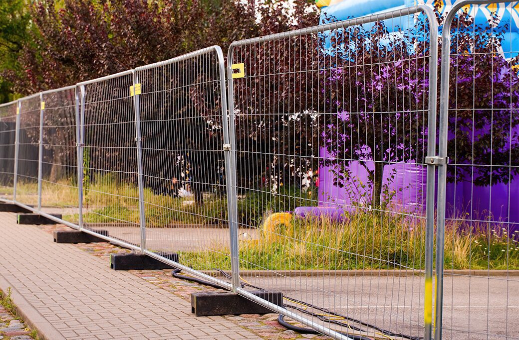 Temporary fencing with stabilizing footings at a construction site